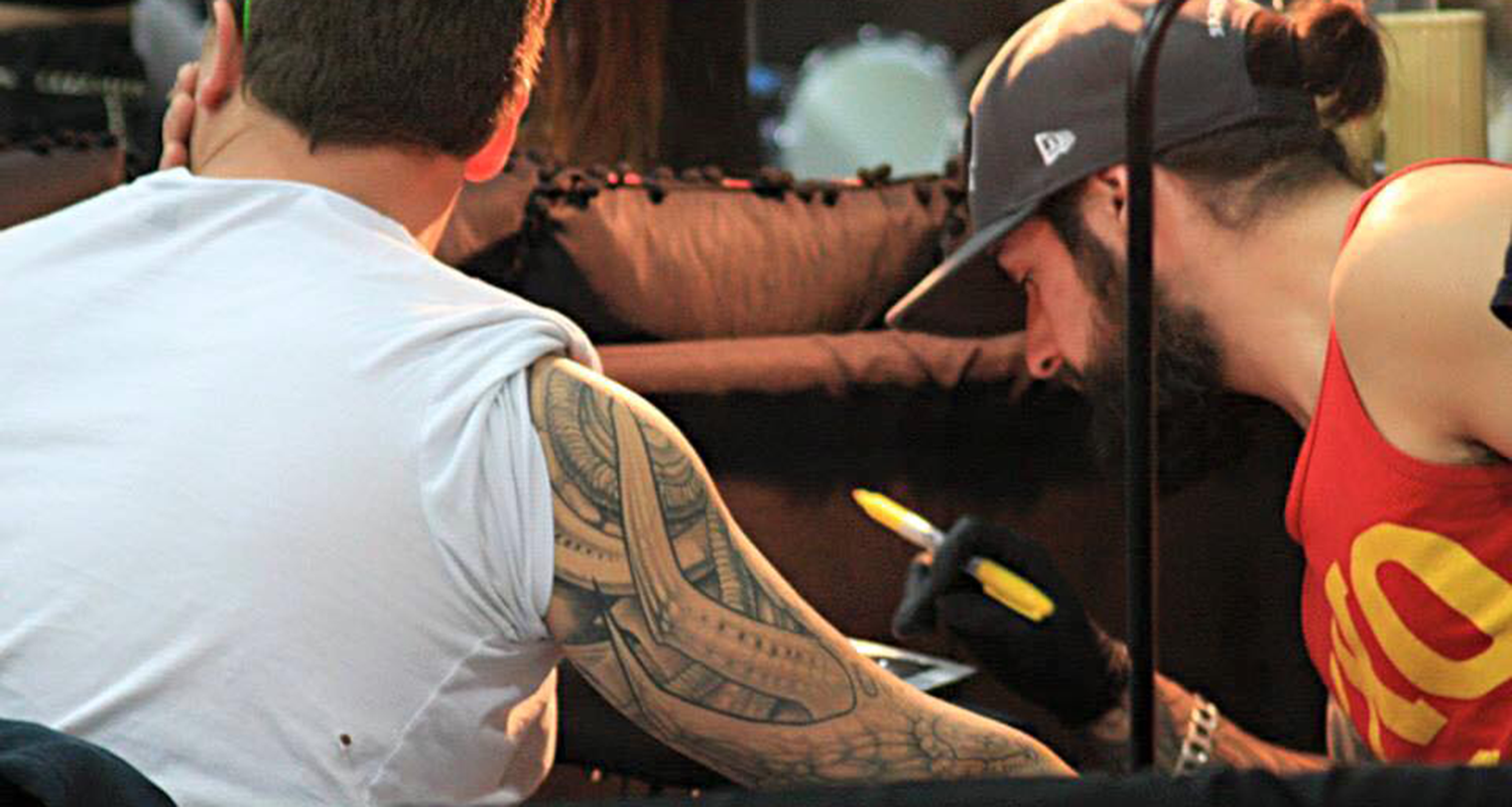 photo of nicolas chalifour tattooing a client