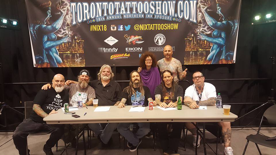 Damien Mcgrath at table with judges at toronto tattoo festival